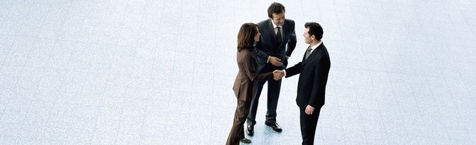 Three business people, man and woman shaking hands.